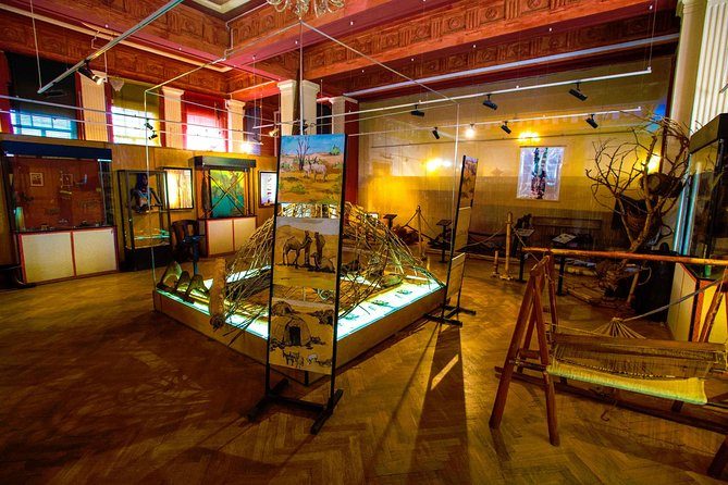 Looms, woven furniture and painted display panels in a museum gallery in Addis Ababa under a coffered painted ceiling