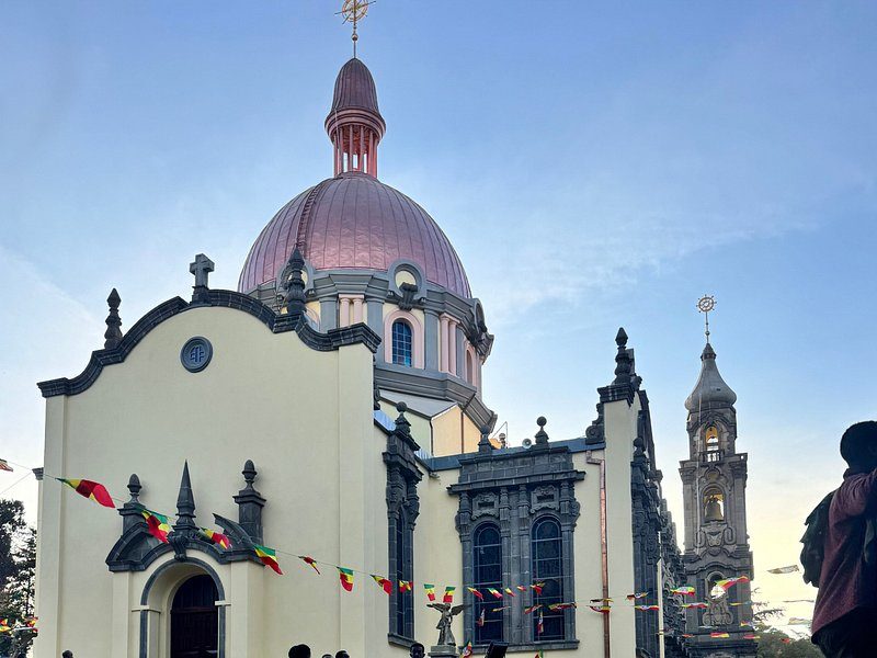 The copper dome and bell tower of Holy Trinity Cathedral in Addis Ababa, strung with Ethiopian flag bunting