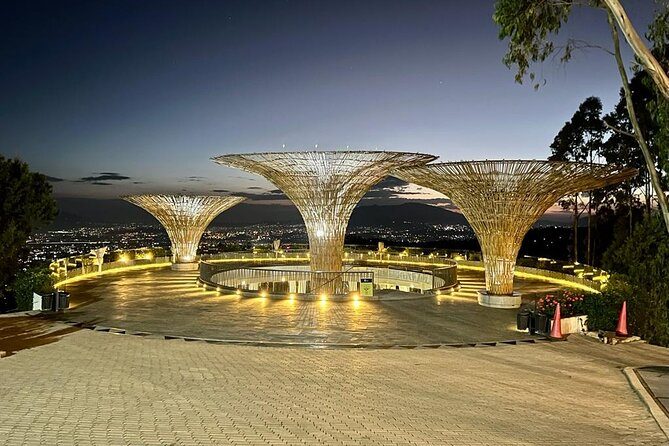 An illuminated viewing terrace with fan-shaped canopies looking out over the lights of Addis Ababa at dusk